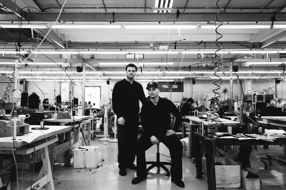 The founders sitting on the studio floor, in black and white